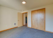 Thumbnail 22 of 27 - A room with a carpeted floor and a wooden door.