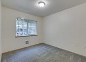 Thumbnail 27 of 33 - A room with a window and a carpeted floor.