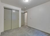 Thumbnail 25 of 33 - A room with a carpeted floor and two closed doors.