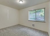 Thumbnail 26 of 33 - A room with a window and a carpeted floor.