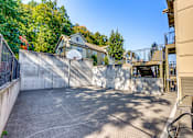 Thumbnail 13 of 33 - A backyard with a basketball court, a fence, and a tree.