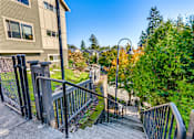 Thumbnail 8 of 33 - A staircase with a metal railing leads up to a building.