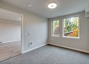 Thumbnail 13 of 22 - A room with a window overlooking a tree-filled landscape.