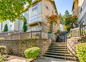 Thumbnail 9 of 33 - A stone wall with a staircase leading up to a building.