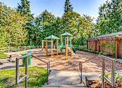 Thumbnail 11 of 33 - A playground with a green canopy and a slide.