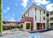 Thumbnail 5 of 12 - A building with a parking space marked with a wheelchair symbol.