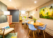 Thumbnail 2 of 12 - A room with a wooden floor and a painting on the wall.