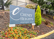 Thumbnail 28 of 29 - A sign for Cheney Heights Apartment Homes is displayed in front of a fence and some trees.