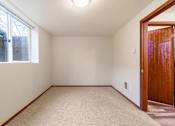 Thumbnail 5 of 29 - A room with a carpeted floor and a door on the right side.