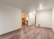 Thumbnail 4 of 29 - A room with wooden flooring and white walls.