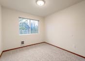 Thumbnail 7 of 29 - A room with a window and a carpeted floor.