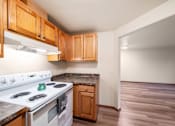 Thumbnail 16 of 29 - A kitchen with a white stove top oven and wooden cabinets.