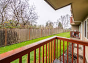 Thumbnail 19 of 29 - A wooden deck with a railing overlooking a backyard.