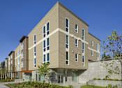 Thumbnail 5 of 22 - A modern building with a mix of beige and brown panels.