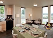 Thumbnail 2 of 22 - A dining room with a table set for a meal.