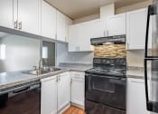 Thumbnail 24 of 40 - a kitchen with white cabinets and black appliances