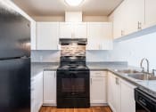 Thumbnail 17 of 40 - a kitchen with white cabinets and black appliances