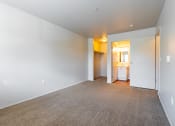 Thumbnail 21 of 40 - a bedroom with a carpeted floor and a bathroom in the background