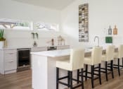 Thumbnail 8 of 40 - a kitchen with white cabinets and a white island with a white countertop and a row of