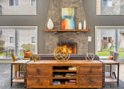 Thumbnail 4 of 40 - a living room with a large stone fireplace and a wooden entertainment center