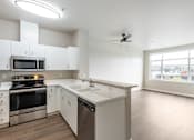 Thumbnail 34 of 40 - A modern kitchen with stainless steel appliances and white cabinets.