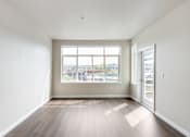 Thumbnail 33 of 40 - A room with a large window and wooden flooring.