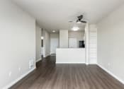 Thumbnail 24 of 40 - A room with a ceiling fan and wooden flooring.