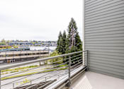 Thumbnail 30 of 40 - A balcony with a metal railing overlooks a cityscape.