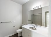 Thumbnail 28 of 40 - A white bathroom with a toilet, sink, and mirror.
