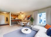 Thumbnail 2 of 22 - A living room with a white couch and a grey rug.
