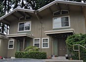 Thumbnail 3 of 3 - A house with a grey exterior and a brown door.
