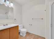 Thumbnail 11 of 20 - a bathroom with a toilet and a sink and a mirror