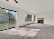 Thumbnail 4 of 20 - an empty living room with a fireplace and a large window
