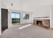 Thumbnail 2 of 20 - a living room with a fireplace and a door to a balcony