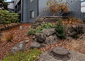 Thumbnail 19 of 21 - A grey house with a rocky front yard.