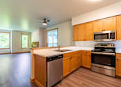 Thumbnail 6 of 40 - A kitchen with wooden cabinets and stainless steel appliances.
