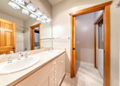 Thumbnail 12 of 40 - A bathroom with a vanity and a mirror.