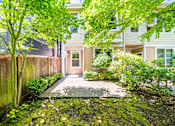 Thumbnail 13 of 40 - A green tree is in front of a building.
