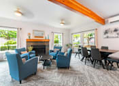Thumbnail 16 of 19 - A living room with blue chairs and a fireplace.