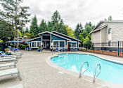 Thumbnail 17 of 19 - A pool with a slide and a house in the background.