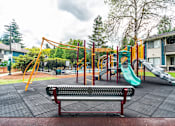 Thumbnail 19 of 19 - A playground with a red bench and a green slide.