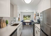 Thumbnail 2 of 41 - a kitchen with white cabinets and stainless steel appliances and a table with blue chairs