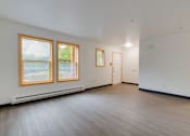 Thumbnail 21 of 24 - A room with wooden floors and a window with a view of trees.