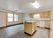 Thumbnail 18 of 24 - A kitchen with wooden floors and cabinets.