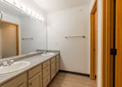 Thumbnail 23 of 24 - A bathroom with two sinks and lights above them.