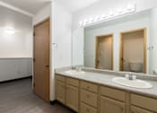 Thumbnail 24 of 24 - A bathroom with a sink, mirror, and wooden door.
