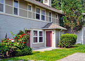 Thumbnail 9 of 24 - A house with a red door and a small porch.