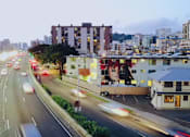 Thumbnail 12 of 12 - A busy street with cars and buildings at dusk.