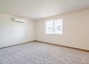 Thumbnail 16 of 19 - A room with a window and carpeted floor.