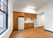 Thumbnail 3 of 22 - an empty kitchen with white appliances and wooden cabinets